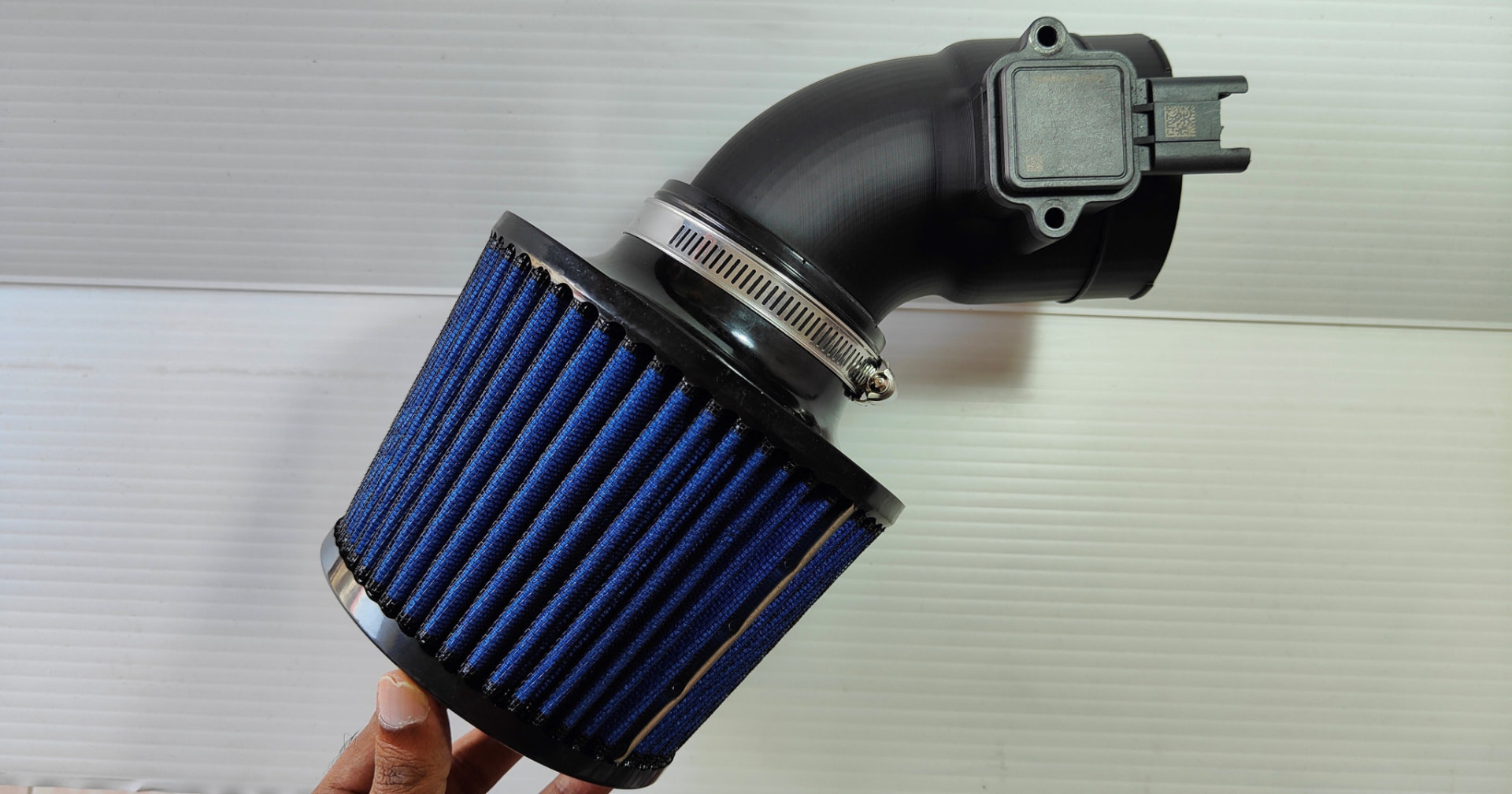 FIXHEN N52 intake adapter with MAF sensor installed, held in hand